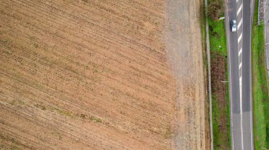 Yukarıdan görülen çorak tarım alanı, doğrusal kuru toprak ve seyrek bitki örtüsü kuraklığı, çölleşmeyi ve iklim baskısını çağrıştıran çapraz desenler oluşturuyor.