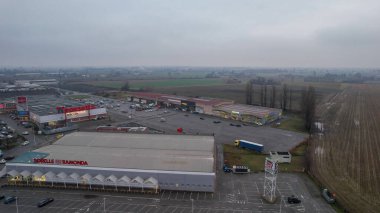 İtalya 'nın Castelvetro Piacentino kentindeki Strada Padana Inferiore kentinde 26 Aralık 2025' te büyük perakende binaları ve boş bir otoparkı bulunan Piacenza kentinde.