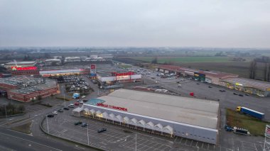 İtalya 'nın Castelvetro Piacentino kentindeki Strada Padana Inferiore kentinde 26 Aralık 2025' te büyük perakende binaları ve boş bir otoparkı bulunan Piacenza kentinde.