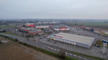 İtalya 'nın Castelvetro Piacentino kentindeki Strada Padana Inferiore kentinde 26 Aralık 2025' te büyük perakende binaları ve boş bir otoparkı bulunan Piacenza kentinde.