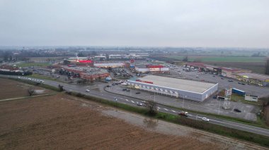 İtalya 'nın Castelvetro Piacentino kentindeki Strada Padana Inferiore kentinde 26 Aralık 2025' te büyük perakende binaları ve boş bir otoparkı bulunan Piacenza kentinde.