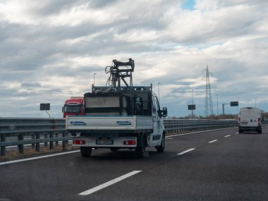 Bir sokak manzaralı harita kamyonu bir minibüsle otoyola çıkıp şehir manzarasının detaylarını yakalıyor. Vicenza, İtalya - 21 Kasım 2025