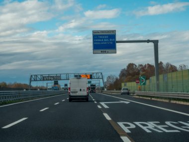 Araçlar, Preganziol, Treviso ve diğer varış noktalarını gösteren bir çıkış işareti olan bir İtalyan otoyolunda sürerler. Vicenza, İtalya - 21 Kasım 2025