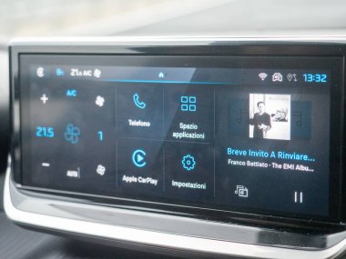 Parlak dokunmatik ekranlı modern araba bilgi işleme sistemi, çeşitli menü seçeneklerini ve ayarlarını gösteriyor. Vicenza, İtalya - 21 Kasım 2025