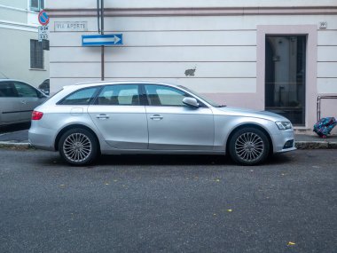Cremona, İtalya - 3 Ekim 2025 Gümüş renkli Audi A4 Avant steyşın vagonu, Via Aporti 'yi gösteren sokak tabelası olan bir binanın yanında park halinde.
