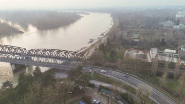 Geniş bir hava perspektifi, İtalya 'nın Cremona kentinden geçen Po Nehri' nin sularını ve kentsel manzarayı çevreleyen önemli bir demiryolu köprüsünü yansıtıyor.