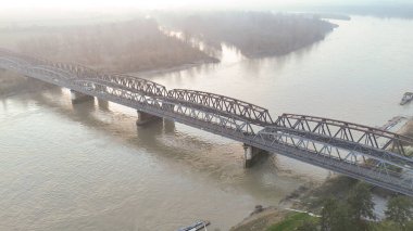 Geniş bir hava perspektifi, Cremona, Lombardy yakınlarındaki Po Nehri 'nin çamurlu sularını kaplayan demiryolu köprüsünün karmaşık çelik yapısını yakalar.