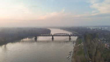 Po Nehri 'ni ve Cremona, Lombardy, İtalya yakınlarındaki tarihi demiryolu köprüsünü sabah sisinde kaplayan panoramik bir dron atışı yakaladı.