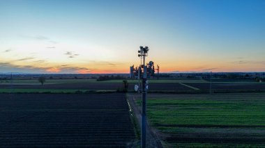 Mavi saat boyunca Po Vadisi kırsalında çoklu 5G antenli baz istasyonu, dingin tarım alanları boyunca gelişmiş telekomünikasyon ve dijital dönüşüm sağlıyor.