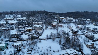 Havadan bakıldığında sakin bir İtalyan dağ köyünü, güneşli bir kış gökyüzünün altında kaplıyor Le Bore, PR, İtalya