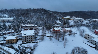 Taze karla kaplı sakin bir İtalyan köyünü, bulutlu gökyüzü Le Bore 'un altında ağaçlık yamaçlara yayılmış evleri, halkla ilişkiler, İtalya