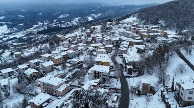Zarif bir kış sahnesi gözler önüne seriliyor. Karlar, İtalyan bir dağ köyü olan Le Bore 'un çatılarını ve etrafındaki tepeleri örtüyor.