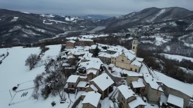 Piacenza 'nın karlı Apennine dağlarına kurulmuş küçük İtalyan köyü Vezzolacca' nın hava manzarası.