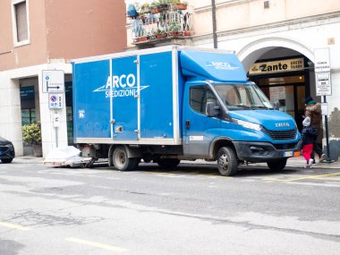 Cremona, İtalya - 24 Aralık 2025 Bir Yunan tavernasının önünden geçen mavi bir teslimat kamyonu