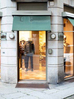 Cremona, İtalya - 24 Aralık 2025 Mankenler ve yeşil tenteli, gösterişli moda ve stili olan bir akıllı mağaza