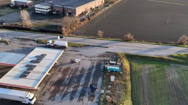 Kamyonları ve otobüsleri olan kırsal bir kamyon durağının hava görüntüsü.