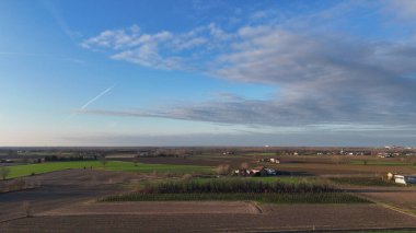 Mavi gökyüzünün altında geniş tarlaları olan sakin kırsal alan