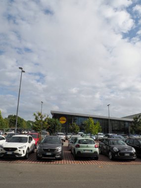 Lombardy, İtalya - 5 Kasım 2025 Parçalı bulutlu bir günde Lidl süpermarketinin önüne park edilmiş araçlar, tipik bir perakende satış sahnesi sergiliyor