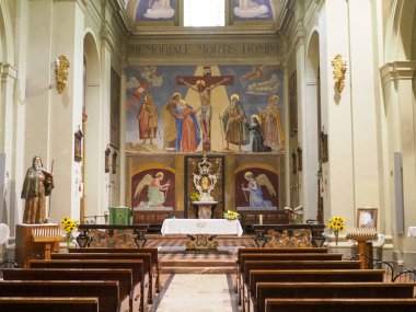 Church nave extending towards the central altar with religious frescoes depicting biblical scenes, statues, and historical artworks, creating a solemn atmosphere for worship and reflection