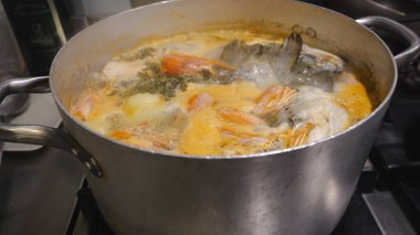 Profesyonel mutfak geleneksel Afrika tatlı patates çorbası, karides ve balık çorbasını ocakta kaynatarak otantik ve sıcak bir mutfak deneyimi yaratıyor.