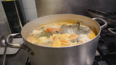 Profesyonel mutfak geleneksel Afrika tatlı patates çorbası, karides ve balık çorbasını ocakta kaynatarak otantik ve sıcak bir mutfak deneyimi yaratıyor.