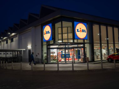 Cremona, İtalya 8 Ocak 2026 İtalyan Cremona şehrinde alacakaranlık derinleştikçe modern bir Lidl market cephesi parlak bir işaret ve iç ışık ile parlıyor.