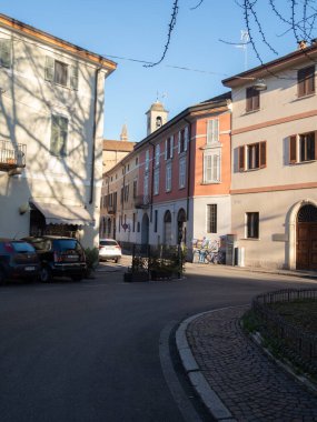 Cremona, İtalya. 8 Ocak 2026. Cremona, İtalya 'da güneş ışığıyla yıkanmış, büyüleyici bir mimari ve uzak bir çan kulesi var.