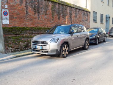 Cremona, İtalya 9 Ocak 2026 Mini Yurttaş E elektrikli SUV, U25 serisi, Eriyen Gümüş III renginde, şehir sokağında tuğla bir duvarın yanına park edilmiş.