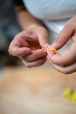 Bir kadının ellerinin titizlikle el yapımı tortelli çekimleri. Klasik İtalyan makarnası. Taze, yerel malzemeler kullanıyor.