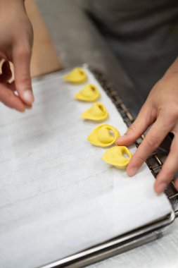 Hassas tortelli makarna şekilleri oluşturan, İtalyan mutfağı geleneği ve taze malzemeler sanatını sergileyen ellerinizi yakın plan çekin.