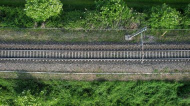 Bir insansız hava aracı İtalya 'nın Po Vadisi' nin canlı yeşil manzarasını kesen bir tren rayının paralel hatlarını yakalıyor.