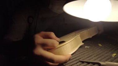 Geleneksel Cremona atölyesinde bir kemanı titizlikle şekillendirmek