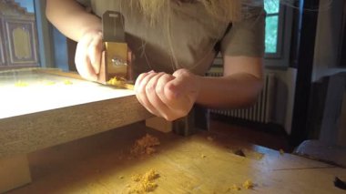 Yetenekli bir zanaatkar titizlikle ip aletleri için ahşap bir yay üzerinde çalışır. Geleneksel zanaatkarlık ve özel bir çalışma alanında detaylara dikkat gösterilir.