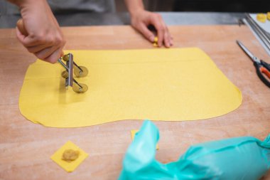 Ev yapımı makarna hamuru ravioli şeklinde kesiliyor.