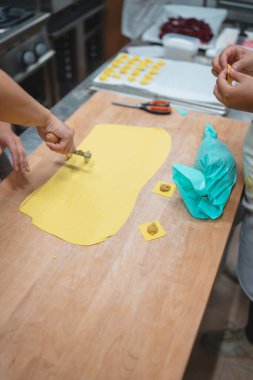 Mutfakta ravioli hazırlamak için ev yapımı makarna hamuru kare şeklinde kesiliyor.