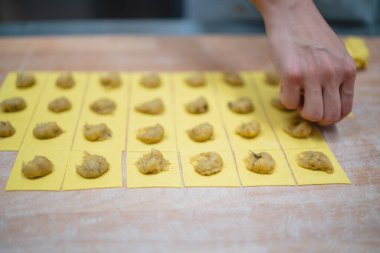 Hamur karelerine doldurarak taze ravioli makarnası hazırlıyorum.