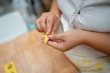 Taze makarna hamurunu ravioli ya da tortellini olarak dikkatlice şekillendiren eller.