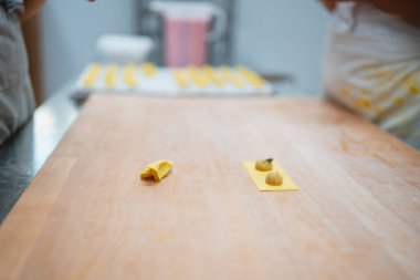 Ev yapımı makarna hamuru ahşap kesme tahtasındaki ravioli için hazırlanıyor.