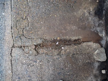 Çatlak ve hasarlı asfalt kaldırımların yakın çekim görüntüsü