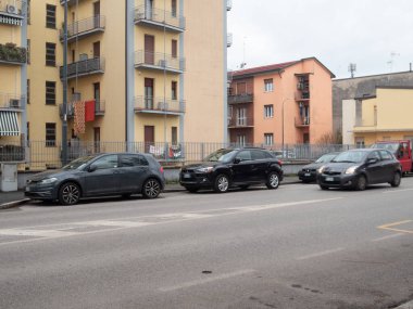 Cremona, İtalya 6 Şubat 2026 Avrupa şehir caddesi boyunca park edilmiş gri Volkswagen Golf hatchback ve siyah Mitsubishi ASX SUV konut binalarının yanında park halindeki araçlar