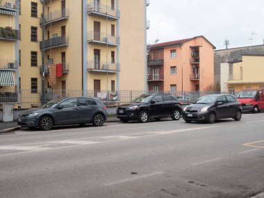 Cremona, İtalya 6 Şubat 2026. Şehir sokağı park halindeki Volkswagen Golf, Mitsubishi ASX ve hareket halindeki Toyota Yaris günlük şehir ulaşımını sergiliyor.