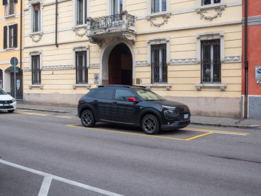 Cremona, İtalya 6 Şubat 2026 Citroen C4 Cactus SUV şehir caddesi boyunca açık bir şekilde işaretlenmiş sarı bir park alanına park edilmiş ve büyüleyici Avrupa mimarisi arka plan olarak hizmet vermektedir.