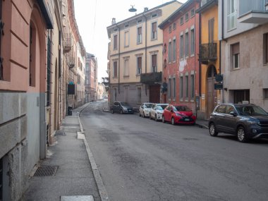 Cremona, İtalya 6 Şubat 2026 eski binalar ve kaldırım kenarına park etmiş çok sayıda arabayla dolu bir şehir manzarası yaratıyor.