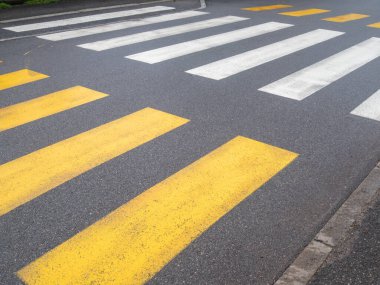 Cremona, İtalya 6 Şubat 2026 Beyaz zebra şeritli yaya geçidi ve asfalt üzerinde sarı yaya geçidi işaretleri var.