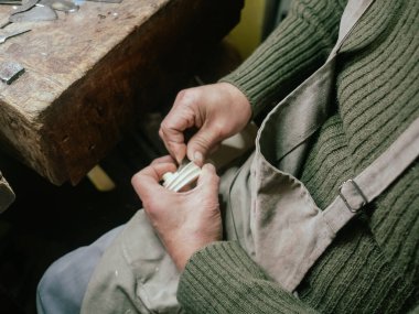 Bir zanaatkarın elleri, tezgahtaki keman için hassas bir parşömeni dikkatlice şekillendiriyor.