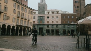 Cremona, İtalya 6 Şubat 2026 Cremonas Piazza del Comune, Lombardiya 'da kış atmosferi. Arka planda bisikletçi ve tarihi Torrazzo kulesi var.