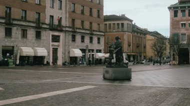 Cremona, İtalya 6 Şubat 2026 Antonio Stradivari heykeli Piazza Stradivari 'de duruyor, tarihi binalar ve gri kış gökyüzü ile çevrili, şehir merkezini simgeliyor.