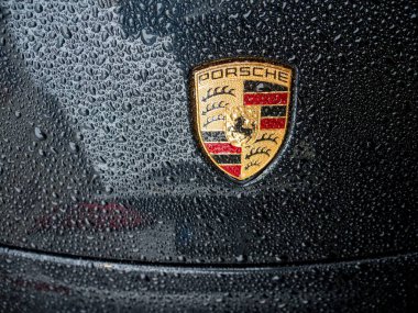 Cremona, İtalya - 6 Şubat 2026 Porsche 911 Carrera 4S (9991.2) amblemi lüks, hassas mühendislik ve otomotiv markasının mirasını yağmur damlalarıyla göstermektedir.