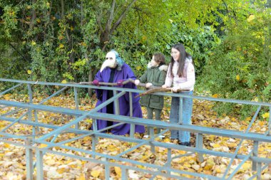 Piacenza, İtalya - 3 Şubat 2022 Veba Doktoru maskeli bir çocuk ve yetişkin, bir ağaç dalı tutarak, doğa ve kirliliğe karşı mücadeleyi sembolize ediyor