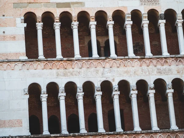 Cremona Katedrali, ortaçağ mimari sanatını vurgulayarak, tarihsel cephesinde ayrıntılı şekillendirilmiş büyük harflerle sıralanmış Romanca kütükler, kemerler ve süslü mermer sütunlar sergiliyor.